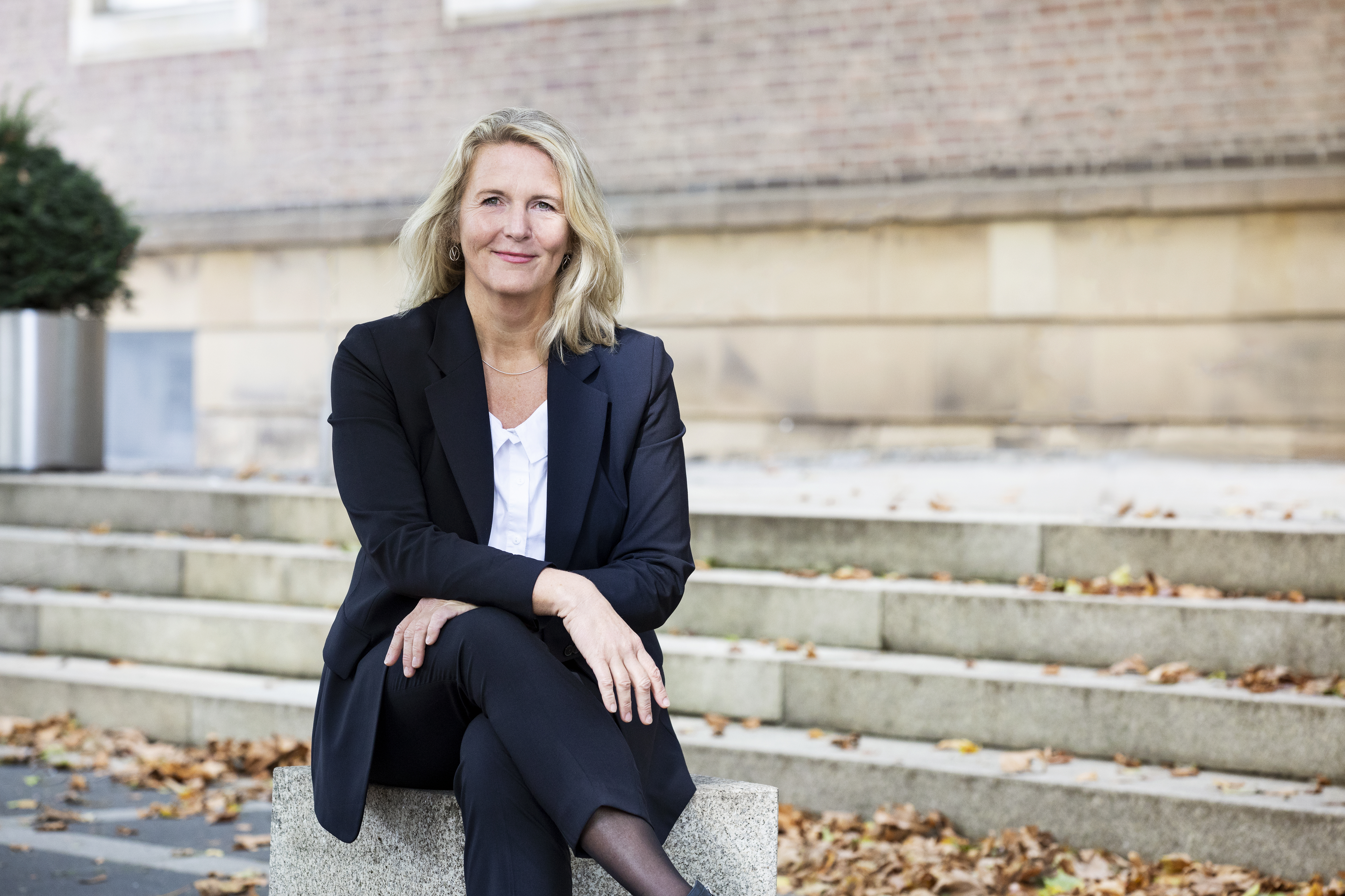 Birgit Neyer sitzt vor dem Landeshaus