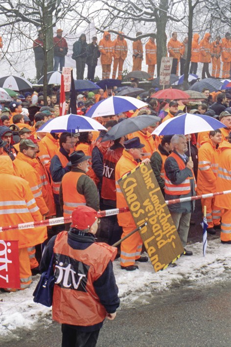 Demonstranten mit Schildern und in Warnwesten