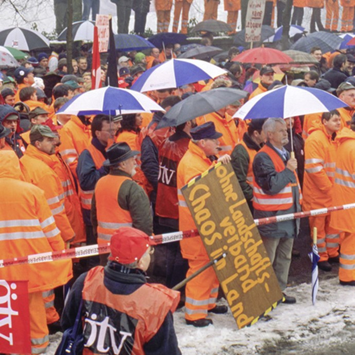 Demonstranten mit Schildern (vergrößerte Bildansicht wird geöffnet)