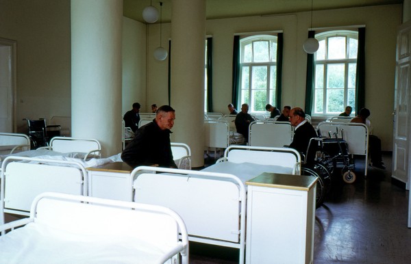 Bettensaal mit mehreren Betten und Patienten