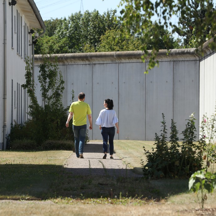 Das Gelände der LWL-Maßregelvollzugsklinik in Herne mit zwei Spaziergänger:innen (vergrößerte Bildansicht wird geöffnet)