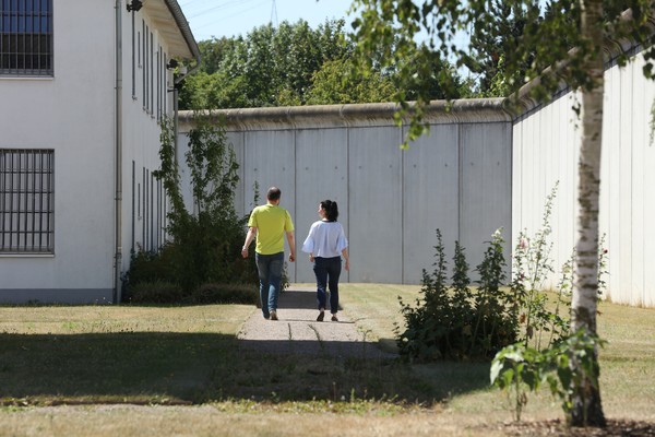 Zwei Spaziergänger:innen auf dem Gelände der LWL-Maßregelvollzugsklinik Herne.